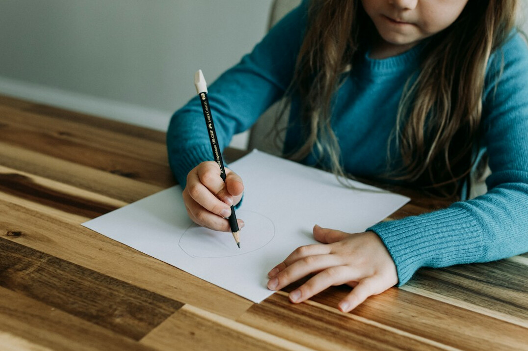 Person deeply focused writing notes at a desk